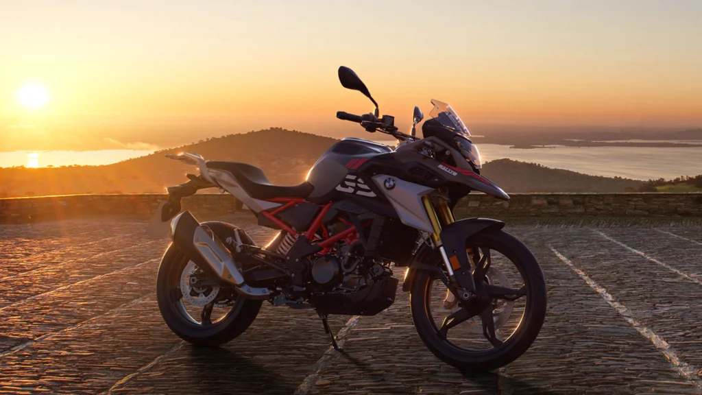 A BMW G310GS Parked in a Paved Road with Mountain and Sunset in Background