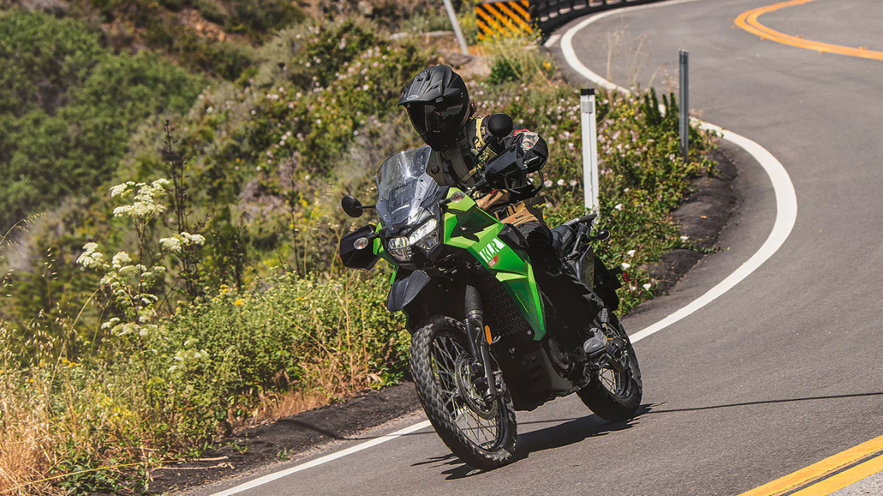 Image of an Kawasaki KLR650 Adventure Motorcycle on a paved road with a rider